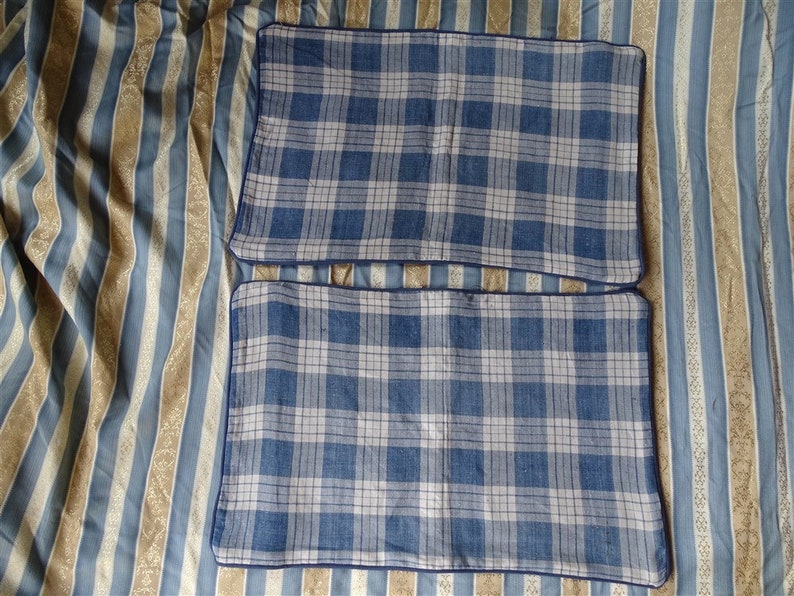 May include: Two blue and white plaid pillowcases with navy blue trim.