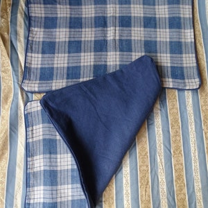 May include: Two blue and white plaid pillow covers with a dark blue border. The pillow covers are on a striped background.