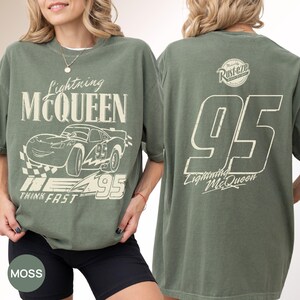 Pu&ograve; includere: T-shirt verde muschio con grafica di Lightning McQueen. La parte anteriore mostra il nome e l'immagine del personaggio, il numero 95 e la frase "Think Fast". Il retro mostra il numero 95 e il logo Lightning McQueen.