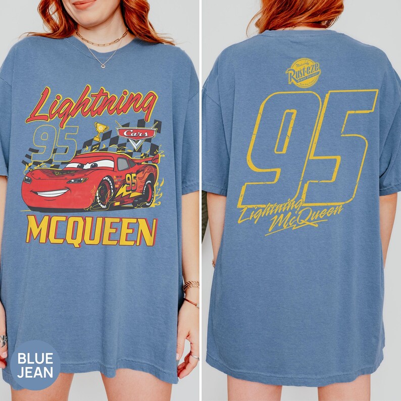 May include: Blue jean t-shirt featuring Lightning McQueen from the Cars movie. The front graphic shows McQueen with the text "Lightning 95 McQueen". The back of the shirt displays a large "95" and "Lightning McQueen" in yellow.