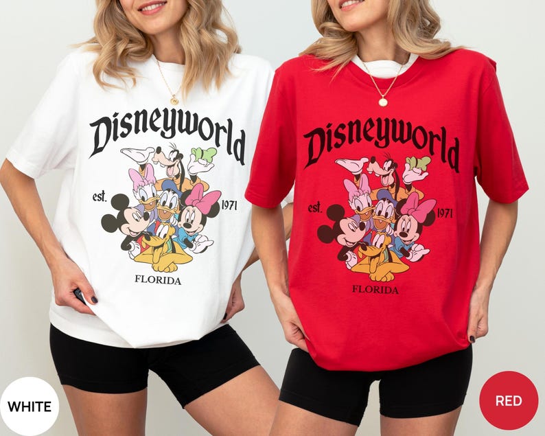 May include: A white t-shirt and a red t-shirt, each featuring a graphic print of Disney characters including Mickey Mouse, Minnie Mouse, Donald Duck, Daisy Duck, Goofy, and Pluto. The text reads Disneyworld, est. 1971, and FLORIDA.