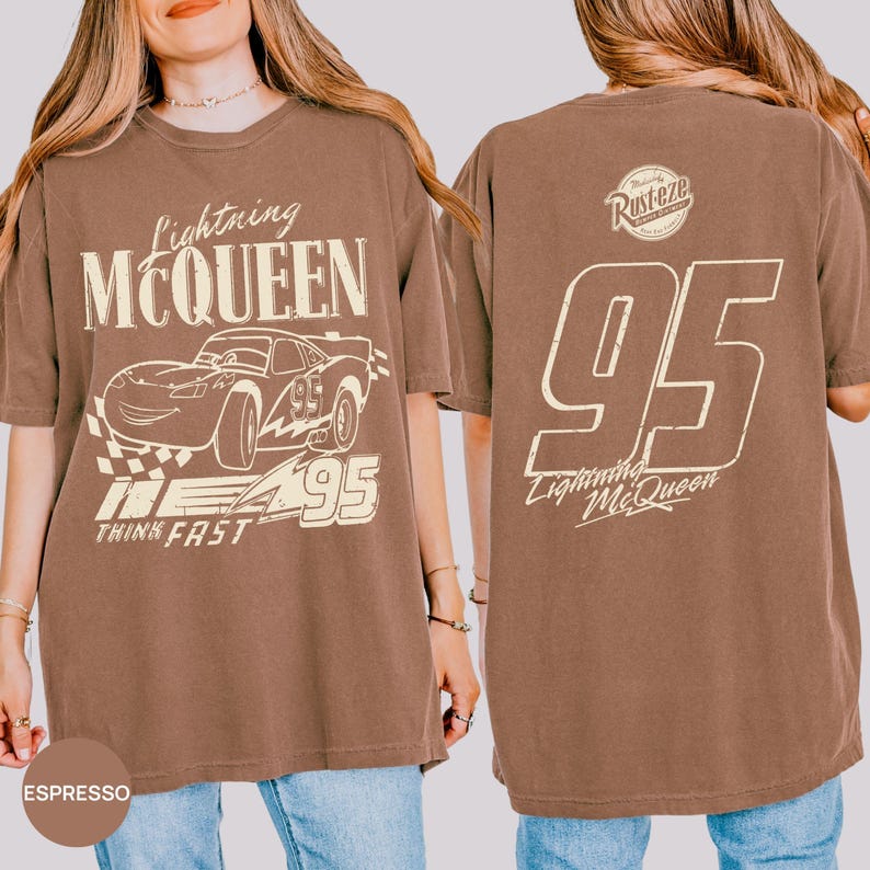 Pu&ograve; includere: T-shirt color espresso con grafica di Saetta McQueen dal film Cars. Il design frontale include il testo "Lightning McQueen", un'illustrazione di auto, il numero "95" e "Think Fast". Il retro mostra "95" e il testo "Lightning McQueen".