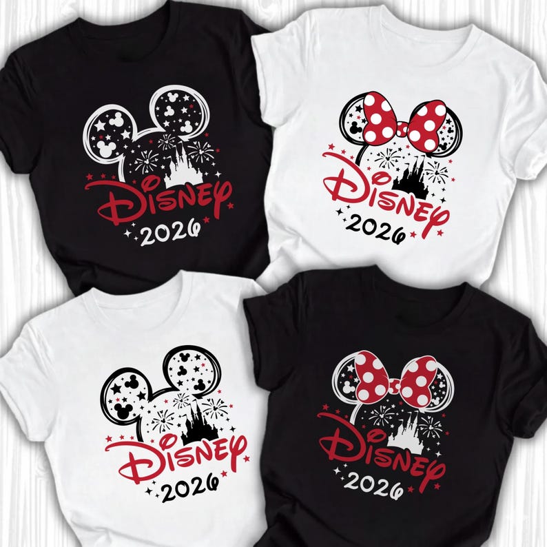 Puede incluir: Cuatro camisetas de manga corta en blanco y negro con un gr&aacute;fico de la silueta de la cabeza de Mickey o Minnie Mouse, un castillo, fuegos artificiales, estrellas y el texto Disney 2026. Dos camisetas incluyen un lazo rojo con lunares.