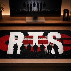 May include: Black rectangular mousepad featuring the letters "BTS" in white, with a red and white striped design behind the letters. Silhouetted figures of people are at the bottom of the mousepad. A computer monitor is in the background.