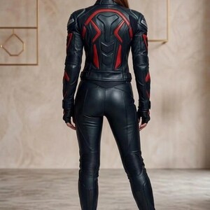 May include: Black leather jacket and pants set with red accents. The jacket features a high collar and red geometric designs on the shoulders and back. The pants have a fitted design with ribbed detailing on the knees.