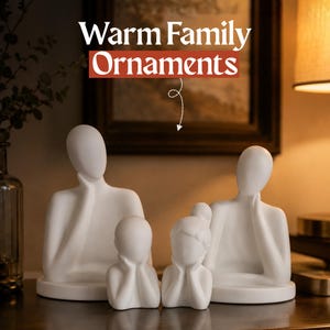 May include: A set of four white matte finish abstract human-shaped ornaments on circular bases. The figures include two larger adult-sized forms and two smaller child-sized forms, all with smooth, featureless faces and hands resting near their chins.