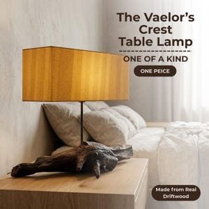Puede incluir: Una lámpara de mesa con una pantalla rectangular de color ámbar con rayas verticales y una base hecha de madera flotante oscura y texturizada. El texto en la imagen dice: The Vaelor's Crest Table Lamp, ONE OF A KIND, ONE PEICE, Made from Real Driftwood.