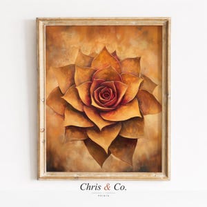 May include: A framed print of a large, stylized rose in shades of orange and red. The artwork has a textured appearance and is set against a warm, neutral background. The frame is a light, neutral colour. The text "Chris & Co. PRINTS" is at the bottom.