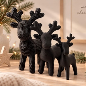Könnte beinhalten: Ein Set aus drei schwarzen Rentierfiguren in verschiedenen Größen. Das größte Rentier hat eine strukturierte, strickartige Oberfläche, während die beiden kleineren eine glatte, matte Oberfläche aufweisen. Jede Figur hat ein Geweih.