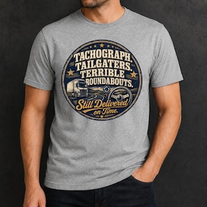 May include: A heather gray crew neck t-shirt featuring a circular graphic with a truck, a steering wheel, and the text: TACHOGRAPH. TAILGATERS. TERRIBLE ROUNDABOUTS. Still Delivered on Time. The design uses dark blue and gold colors.