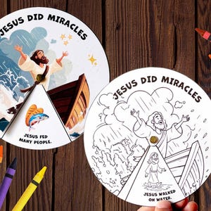 以下が含まれることがあります： 「JESUS DID MIRACLES」と書かれた2つの円形ペーパーアクティビティホイール。1つはボートのシーンと魚が描かれたカラー版で、もう1つは水の上を歩くシーンが描かれた白黒の線画です。周囲にはクレヨンが置かれています。