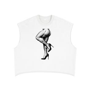 Op de afbeelding: Een witte mouwloze crop top met een zwart-witte grafische illustratie van een gespierd been dat een naaldhak draagt. Het ontwerp toont een gedetailleerde schets van een kuit en dijbeen met een pump met een puntige neus aan de voet.