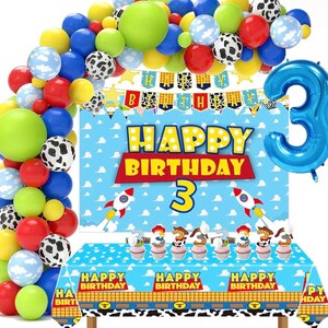 May include: A birthday party decoration set featuring a blue sky and cloud backdrop with the text Happy Birthday and a large number 3. Includes a matching tablecloth, a blue number 3 balloon, and a balloon arch in red, blue, green, yellow, and cow print.