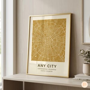 May include: A framed map print with a gold-colored frame. The map features a detailed, circular street layout in shades of gold and cream. The text "ANY CITY" is displayed at the bottom, along with "COORDINATES • ANYWHERE STATE | COUNTRY."