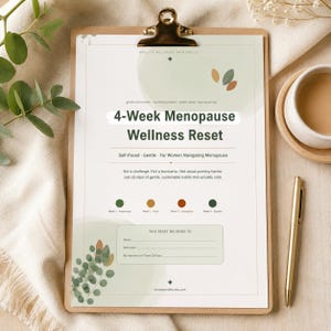 Könnte beinhalten: Ein ausdruckbares 4-Week Menopause Wellness Reset Dokument auf einem braunen Klemmbrett. Die Seite zeigt grüne und orangefarbene Blattgrafiken, Text zu einem 28-Tage-Gewohnheitsprogramm, vier farbige Kreise für wöchentliche Themen und ein Feld.