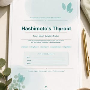Puede incluir: Una guía imprimible blanca titulada "Hashimoto's Thyroid" con texto y detalles en color turquesa. La guía incluye secciones para rastrear la alimentación, el estado de ánimo y los síntomas. Un bolígrafo dorado y clips están a la derecha.