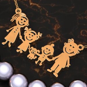 May include: A gold-colored family pendant necklace featuring a mother, father, and three children, including a dog. The pendant is on a gold chain, with a pearl necklace in the foreground. The figures are stylized.