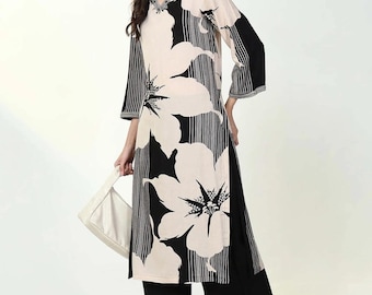 May include: A black and white floral print long-sleeved top with a V-neckline and a matching pair of black palazzo pants with a white floral trim.