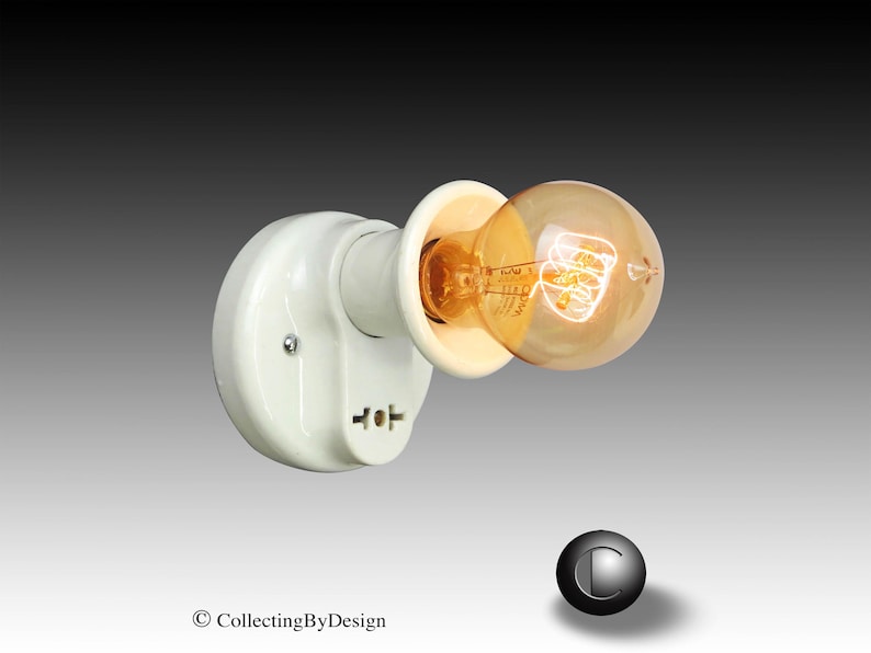 Puede incluir: Un aplique de luz de estilo vintage con una base de porcelana blanca y una bombilla Edison de tonos c&aacute;lidos. La bombilla redonda emite un brillo &aacute;mbar suave. El aplique est&aacute; dise&ntilde;ado para montaje en pared y tiene una est&eacute;tica industrial cl&aacute;sica.