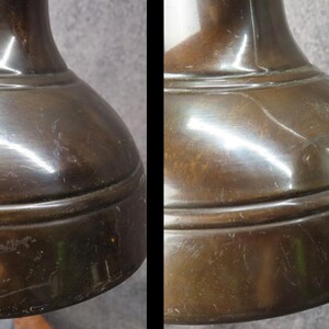 Puede incluir: Primer plano de una base de l&aacute;mpara de color bronce. La base tiene una forma redondeada, como de campana, con una superficie ligeramente texturizada. El metal refleja la luz, creando reflejos y sombras. La base de la l&aacute;mpara parece ser vintage o antigua.