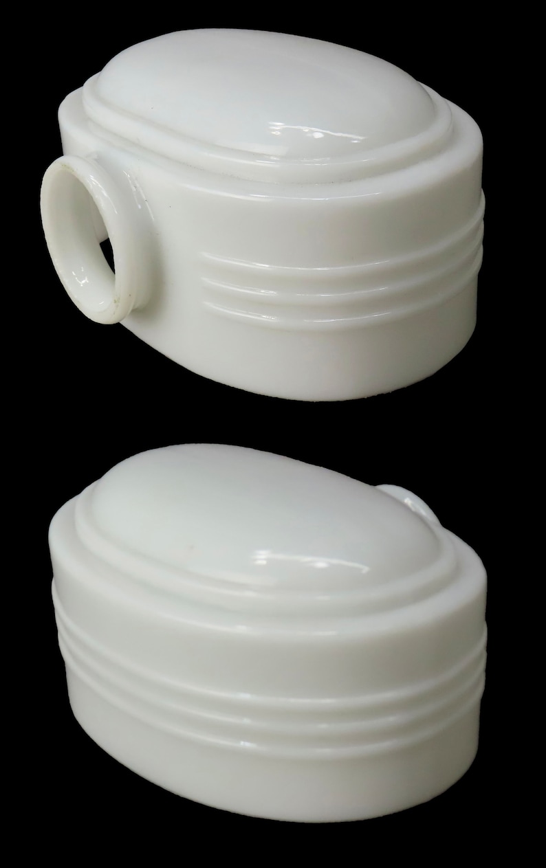 Puede incluir: Dos l&aacute;mparas blancas de forma ovalada, con una parte superior redondeada y tres ranuras horizontales. Una l&aacute;mpara tiene un peque&ntilde;o asa circular. Las l&aacute;mparas est&aacute;n sobre un fondo negro.