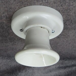 Puede incluir: Una l&aacute;mpara de techo de cer&aacute;mica blanca con una base redondeada y un casquillo acampanado. La l&aacute;mpara se fija al techo con dos tornillos. La l&aacute;mpara es de dise&ntilde;o cl&aacute;sico.