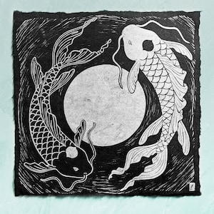 Puede incluir: Grabado en madera en blanco y negro de dos peces koi nadando alrededor de un círculo. Los peces se miran y tienen escamas detalladas.