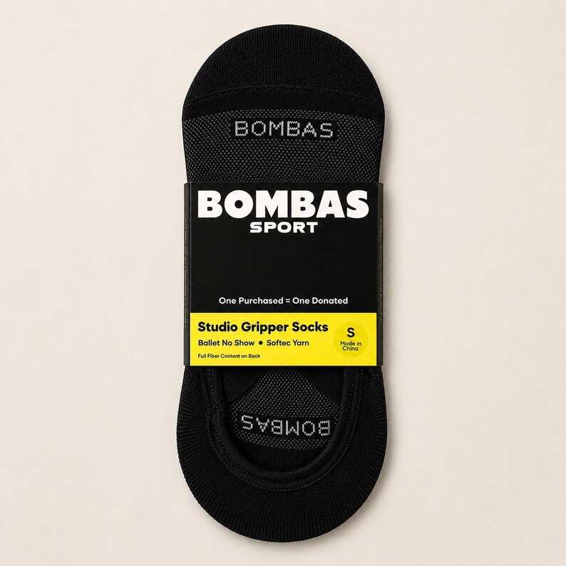 Pode incluir: Meias pretas Studio Gripper com a marca "BOMBAS" impressa na parte superior e inferior. As meias s&atilde;o embaladas com uma etiqueta preta e amarela que diz "BOMBAS SPORT" e "Studio Gripper Socks".