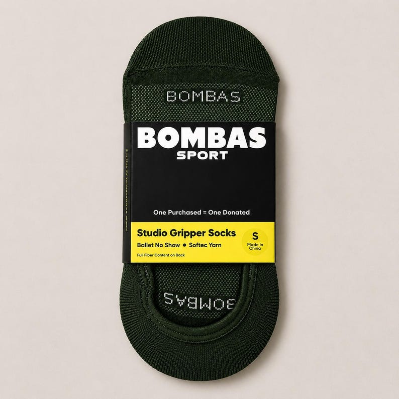 Pode incluir: Meias Studio Gripper sem costura verde escuro da Bombas. A embalagem preta e amarela diz "BOMBAS SPORT" e "One Purchased = One Donated". As meias s&atilde;o tamanho S e feitas com Softec Yarn.
