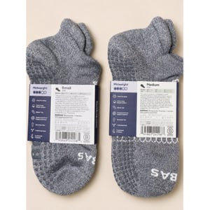 May include: Two pairs of gray midweight ankle socks with white labels. The socks have a textured pattern on the bottom and the brand name "BAS" in white. The labels indicate "Small" and "Medium" sizes.