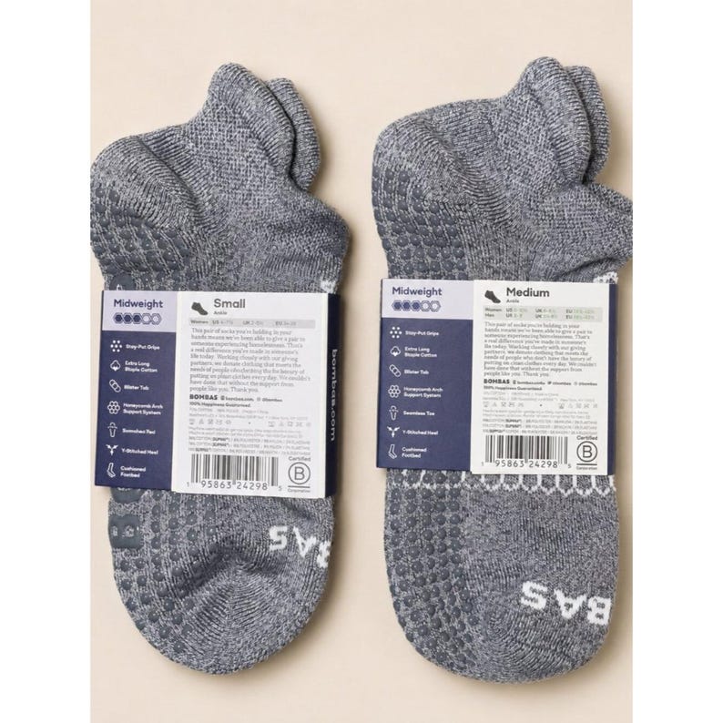 May include: Two pairs of gray midweight ankle socks with white labels. The socks have a textured pattern on the bottom and the brand name "BAS" in white. The labels indicate "Small" and "Medium" sizes.