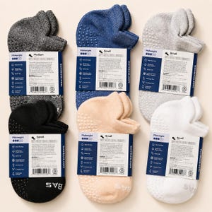 May include: An assortment of six pairs of Midweight socks in various colors, including gray, navy blue, light gray, black, beige, and white. Each pair has a non-slip grip and is labeled with the brand name and size.
