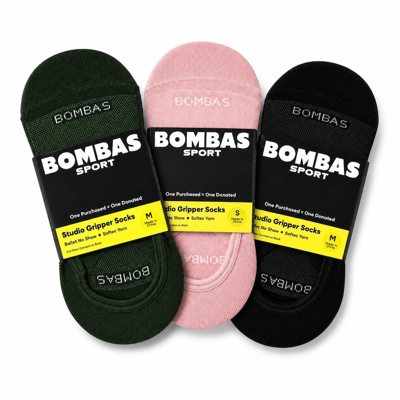 Pode incluir: Tr&ecirc;s pares de meias Bombas Studio Gripper em verde, rosa e preto. Cada par &eacute; embalado com uma etiqueta preta que diz "BOMBAS SPORT" e "Studio Gripper Socks". As meias s&atilde;o projetadas para bal&eacute; e apresentam fio Softec.
