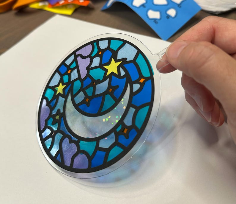 Moon and stars suncatcher kit held in a hand for scale