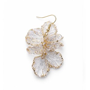 May include: A single gold-tone earring featuring a floral design. The earring has three layered, translucent, petal-shaped elements with gold trim. The earring hook is gold-colored.