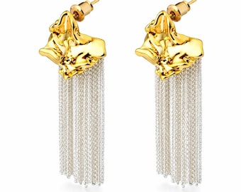 May include: A pair of gold-tone earrings with a textured, organic shape at the top and cascading silver-tone chain fringe. The earrings have a post-back closure and are displayed against a white background.