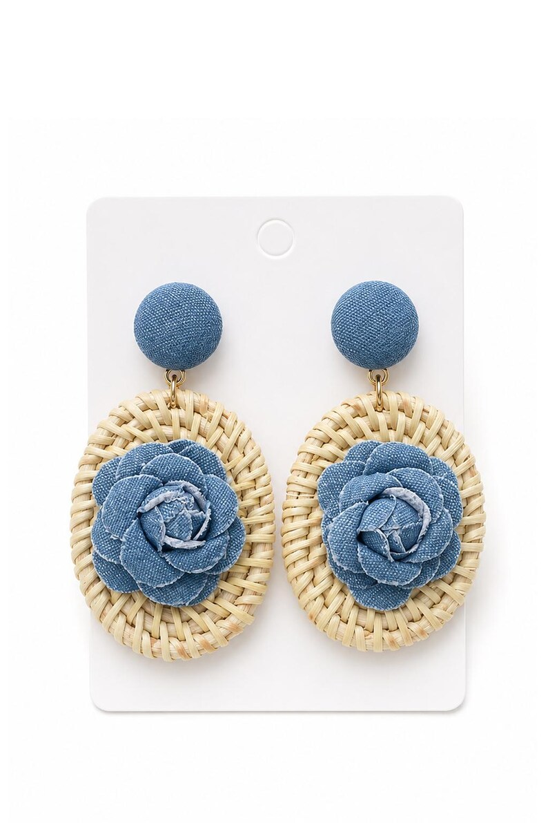 May include: A pair of dangle earrings featuring a circular denim-covered stud top connected to an oval-shaped woven rattan base. Each earring is centered with a layered denim fabric flower, showcasing a blue textile texture and natural tan wicker.
