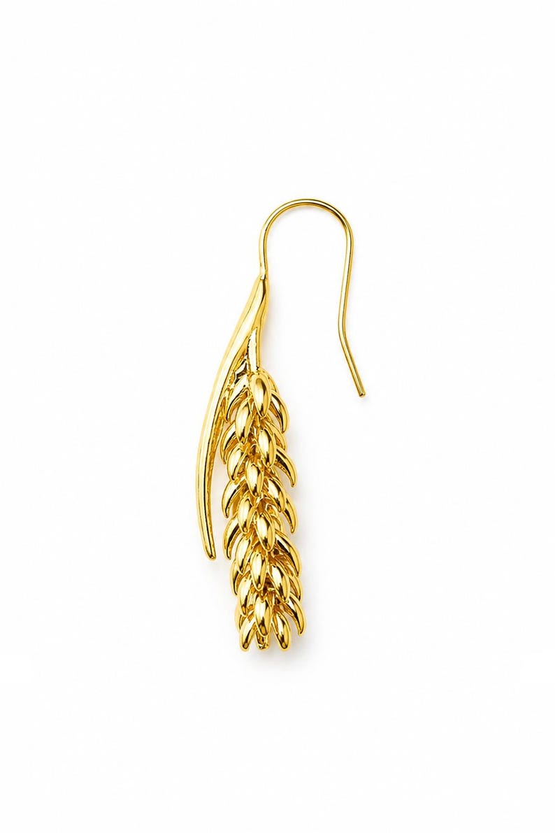 May include: A single gold-colored earring with a wheat stalk design. The earring features a curved hook and a detailed, textured wheat stalk pendant. The overall design is elegant and minimalist, with a bright, reflective finish.