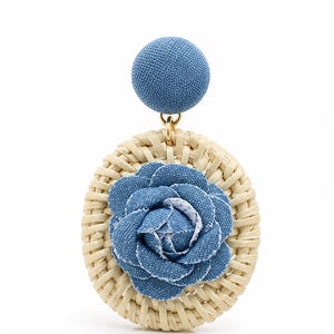 May include: A dangle earring featuring a circular woven rattan disc with a blue denim fabric flower at the center. A small gold-tone metal jump ring connects the rattan disc to a round, blue denim fabric-covered stud top component.