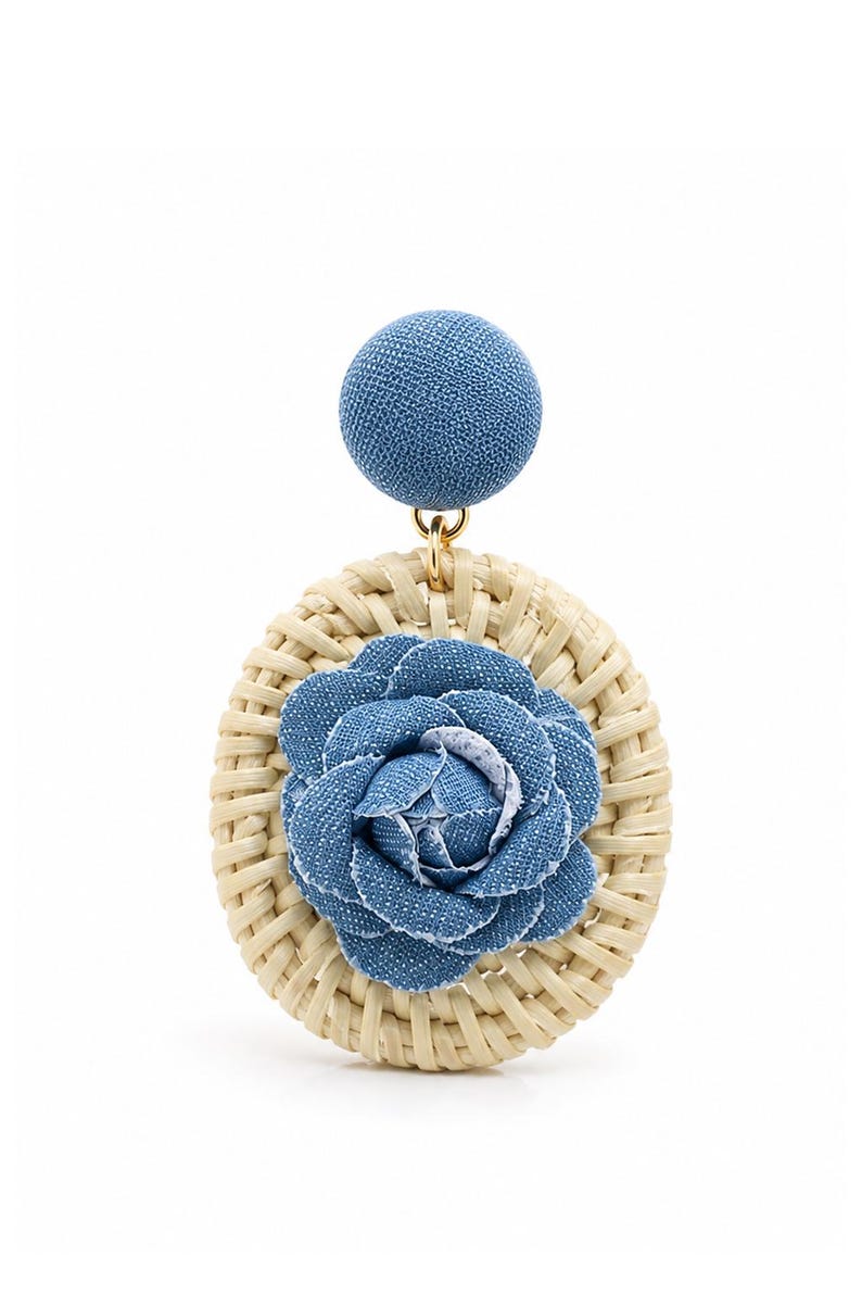 May include: A dangle earring featuring a circular woven rattan disc with a blue denim fabric flower at the center. A small gold-tone metal jump ring connects the rattan disc to a round, blue denim fabric-covered stud top component.