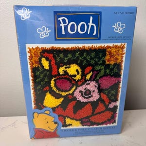 May include: A blue rectangular box for a Tigger and Piglet latch hook kit. The box features the text Pooh, Art No. WP0007, and Approx. Size 13 inches x 13 inches. The front displays a colorful latch hook design of Tigger and Piglet.