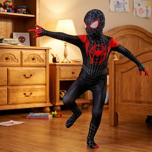 Puede incluir: Un disfraz de Spider-Man negro y rojo con un patr&oacute;n de telara&ntilde;a, detalles rojos y un emblema de ara&ntilde;a en el pecho. El traje de cuerpo completo incluye una m&aacute;scara con detalles de ojos blancos y guantes y suelas rojas. El disfraz es para ni&ntilde;os.
