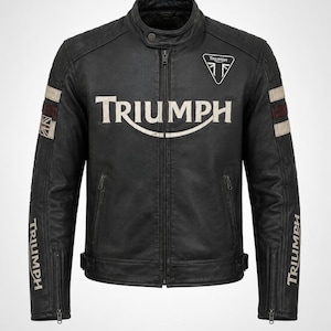 May include: A black leather motorcycle jacket featuring a stand-up collar with a snap button, a central zipper, and two zippered side pockets. The chest displays the word TRIUMPH in white, with a small logo above. Sleeves have stripes and text.