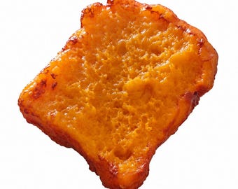 May include: A single slice of golden-orange French toast with a porous, textured surface and slightly browned, crisp edges. The bread slice has an irregular, somewhat rectangular shape with a glossy, cooked appearance throughout the entire piece.