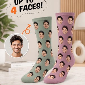 May include: Two crew-length socks featuring a repeating pattern of a man's face. One sock is sage green and the other is mauve. A circular inset shows the original face photo, and text above reads UP TO 4 FACES! with an orange arrow pointing down.