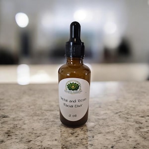 Puede incluir: Un frasco de vidrio ámbar con tapa de gotero negra que contiene un elixir facial. La etiqueta blanca presenta un gráfico de loto verde, el texto Holistic Harmony, Petal and Resin Facial Elixir y el volumen de 59 ml.