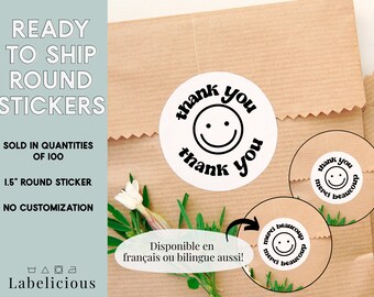 May include: White round stickers with black text and a smiley face. The stickers say "thank you" and "merci beaucoup".