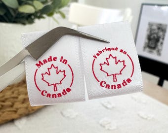 May include: Two white fabric labels with red text and a red maple leaf design. The label on the left says "Made in Canada" and the label on the right says "Fabriqué au Canada".