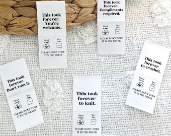May include: Five white fabric care labels with black text and icons. The labels read "This took forever. You're welcome." "This took forever. Compliments required." "This took forever. Don't ruin it." "This took forever to knit." and "This took forever to crochet." Each label includes hand wash and dry flat icons and the text "Please don't toss it in the dryer."