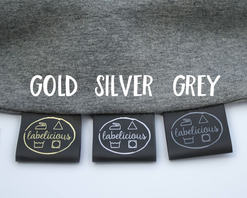 May include: Three black fabric labels with the words "labelicious" printed in gold, silver, and grey. The labels are attached to a grey fabric background with the words "GOLD", "SILVER", and "GREY" printed in white.